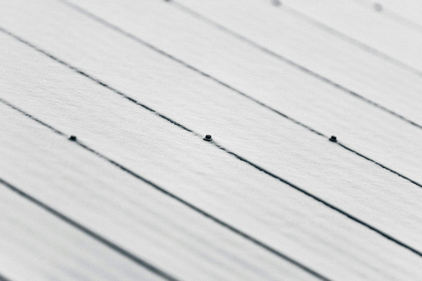 Neve fresca copre parzialmente un tetto a standing seam in metallo.